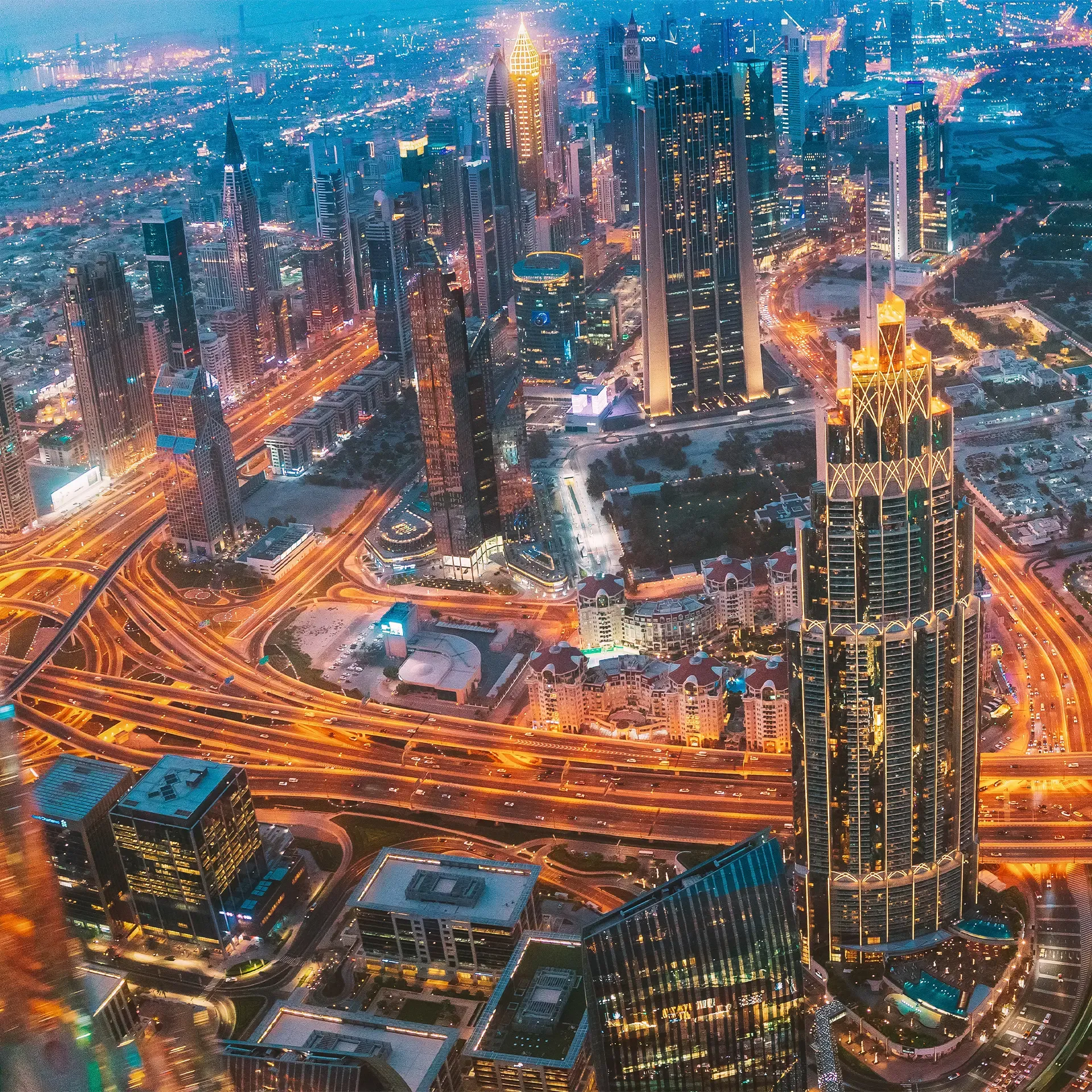 Panoramic view of the Downtown Dubai skyline featuring the Burj Khalifa and high-rise luxury apartments at sunset.