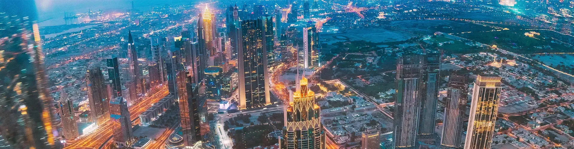 Panoramic view of the Downtown Dubai skyline featuring the Burj Khalifa and high-rise luxury apartments at sunset.